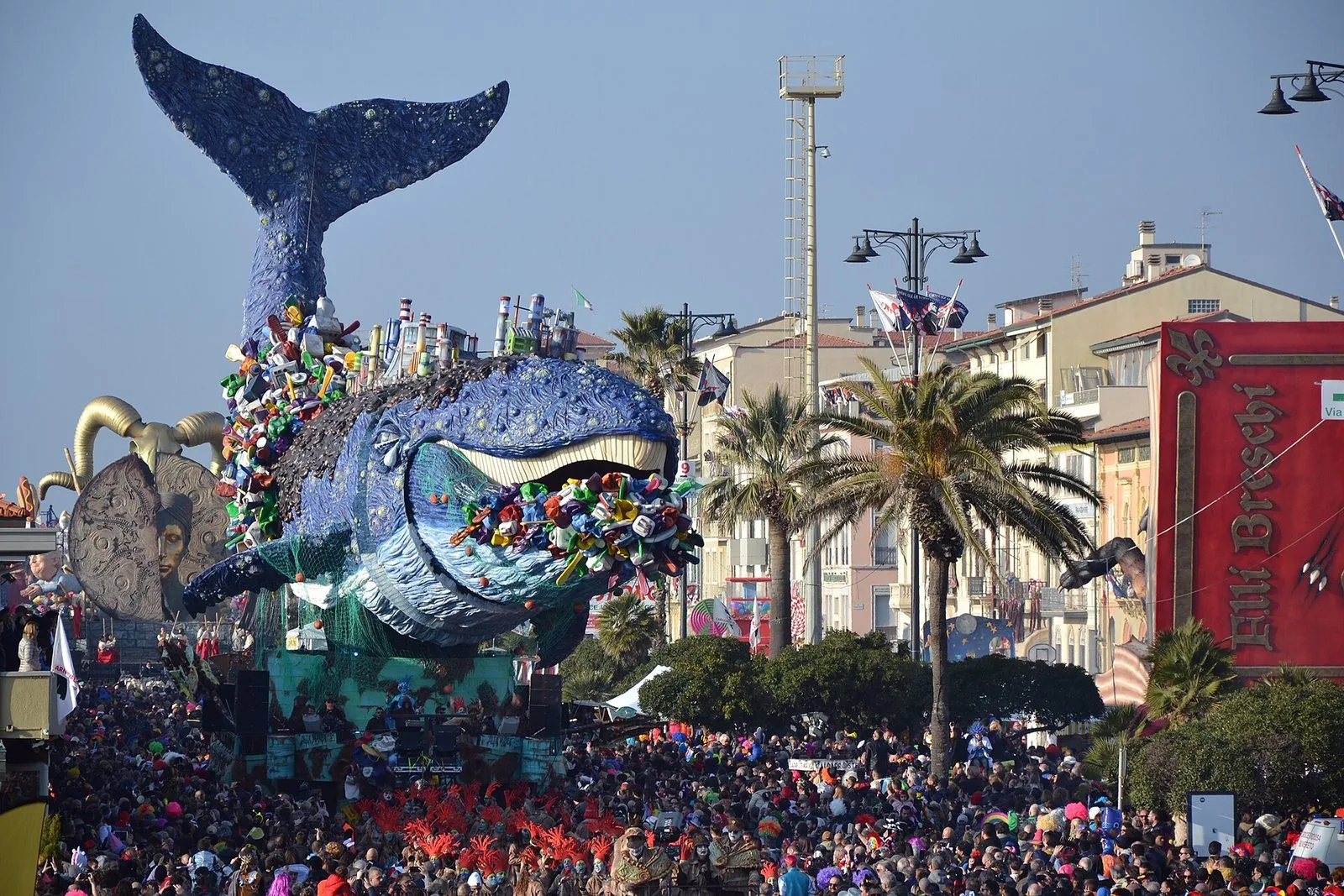 Enorme carro allegorico a forma di balena sfila tra la folla sul lungomare del Carnevale di Viareggio
