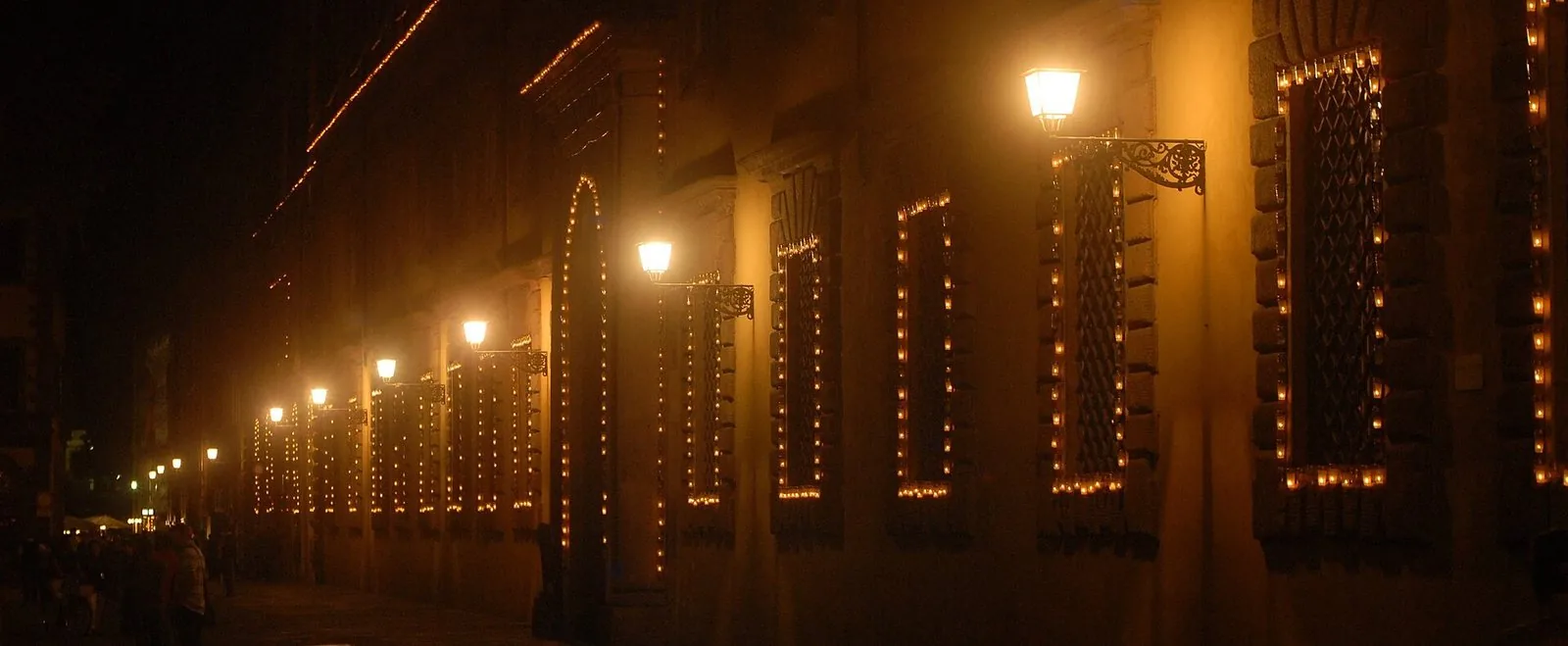 Finestre dei palazzi di Lucca contornate da migliaia di lumini durante la Luminara di Santa Croce